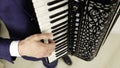 The accordionist`s fingers run over the black and white keys.