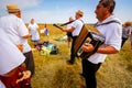 Accordionist stretches bellow of harmonic, music for good harvest