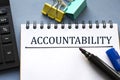 ACCOUNTABILITY word is written in a notebook with a marker, calculator, clamps and cactus