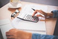 The accountant`s hand is using the calculator. For cost analysis Profit and loss and tax calculation concept preparation of Royalty Free Stock Photo