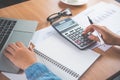 The accountant`s hand is using the calculator. For cost analysis Profit and loss and tax calculation concept preparation of Royalty Free Stock Photo