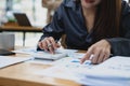 Accountant woman working on desk office with using a calculator to calculate the numbers, finance accounting concept Royalty Free Stock Photo