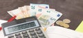 Accounting and business management Banknotes, calculator and Euro banknotes on wooden background. Tax, debit and costing.