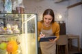 Cafe owner checking desserts in a display case