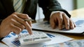 At the accounting desk, an accountant presses a calculator to analyze investment charts to generate monthly financial reports or c Royalty Free Stock Photo