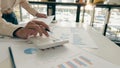 At the accounting desk, an accountant presses a calculator to analyze investment charts to generate monthly financial reports or c Royalty Free Stock Photo