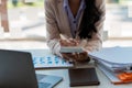 At the accounting desk, an accountant presses a calculator to analyze investment charts to generate monthly financial reports or c Royalty Free Stock Photo