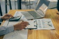 At the accounting desk, an accountant presses a calculator to analyze investment charts to generate monthly financial reports or c Royalty Free Stock Photo