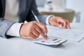 Accounting for every penny in his business. Closeup shot of an unrecognisable businessman using a calculator while going