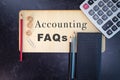 Accounting FAQs wooden sign with office tools and supplies