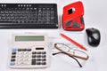 Accounting: invoice, keyboard, calculator, mouse, hole punch, glasses and red pen Royalty Free Stock Photo