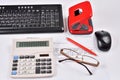 Accounting: invoice, keyboard, calculator, mouse, hole punch, glasses and red pen Royalty Free Stock Photo