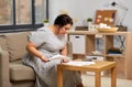 Woman with bills or papers and calculator at home