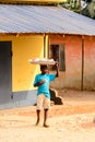 Unidentified Ghanaian boy carries a basin on his head. Children Royalty Free Stock Photo