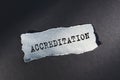 ACCREDITATION - text on torn paper on dark desk in sunlight