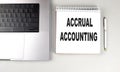 ACCRUAL ACCOUNTING text on notebook with laptop and pen