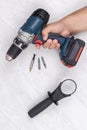 Accu battery drill in the hand on the white background with hand mount holder. Do it yourself concept with hand drill