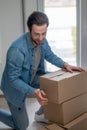 Man kneeling down stacking boxes indoors