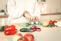 Accurate skilled woman cutting cucumber with professional knife