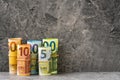 Accurately rolled hundred, fifty, twenty, ten and five paper euro banknotes on the grey stone background