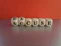 Accuse and excuse symbol. Turned cubes and changes the word accuse to excuse. Beautiful grey table red background.