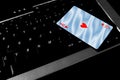 Ace of hearts card lies on top of a laptop keyboard