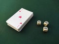 The ace of hearts lies on top of the deck of playing cards. Nearby are three bone cubes Royalty Free Stock Photo