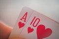 Ace of hearts and ten of hearts, Playing cards in hand on the table, poker nands