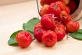 Acerola cherry in wooden bucket on wooden background. Select  focus, Barbados cherry, Malpighia emarginata, high vitamin . Acerola Royalty Free Stock Photo