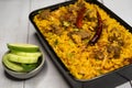 Achari beef khichuri biryani rice pulao with cucumber and lemon slice served in dish isolated on wooden table side view of Royalty Free Stock Photo