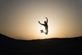 Achieve main goal. Silhouette man motion jump in front of sunset sky background. Future success depends on your efforts