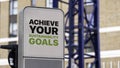 Achieve Your Sustainability Goals sign in a city setting under construction