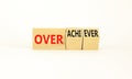 Achiever or overachiever symbol. Businessman turns wooden cubes and changes word Achiever to Overachiever. Beautiful white