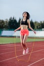 Achieving best results. Beautiful young brunette woman in sports clothing skipping rope and smiling while exercising on the Royalty Free Stock Photo