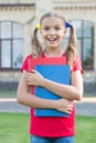 Achieving high standards. Cute little bookworm. Cute smiling small child hold books educational institution background Royalty Free Stock Photo