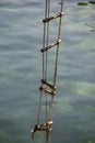 Achieving success. Rope ladder. Jacobs ladder. Rope ladder with wooden steps. Rope over water surface. Rescue or escape