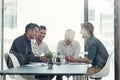 Achieving success together as a team. a group of businessmen having a meeting around a table in an office. Royalty Free Stock Photo