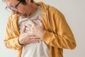 Aching chest, adult male with painful grimace pressing the upper abdomen with his hands to ease pain Royalty Free Stock Photo