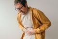 Aching stomach pain, man pressing the lower abdomen of his body with painful grimace