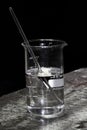 Acid and glass rod in a glass beaker