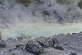 Acidic hot spring stream water with hydrochloric acid emitting steam in mountain valley at Tamagawa Onsen Hot spring in Japan