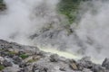 Acidic hot spring stream water with hydrochloric acid emitting steam in mountain valley at Tamagawa Onsen Hot spring in Japan