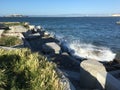 The Wave Organ with spray up along the walk with Alcatraz Island in the back left. Royalty Free Stock Photo