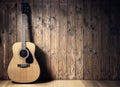 Acoustic guitar against blank wooden plank panel grunge background with copy space Royalty Free Stock Photo