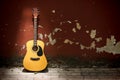 Acoustic guitar against grungy wall Royalty Free Stock Photo
