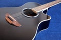 Acoustic guitar with black top with six strings closeup Royalty Free Stock Photo