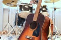 Acoustic guitar close up with drum kit in background