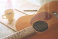 Acoustic guitar and a cup of coffee on background