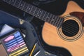 Acoustic guitar and digital tablet with a music application, top view.