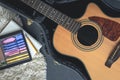 Acoustic guitar and digital tablet with a music application, top view.